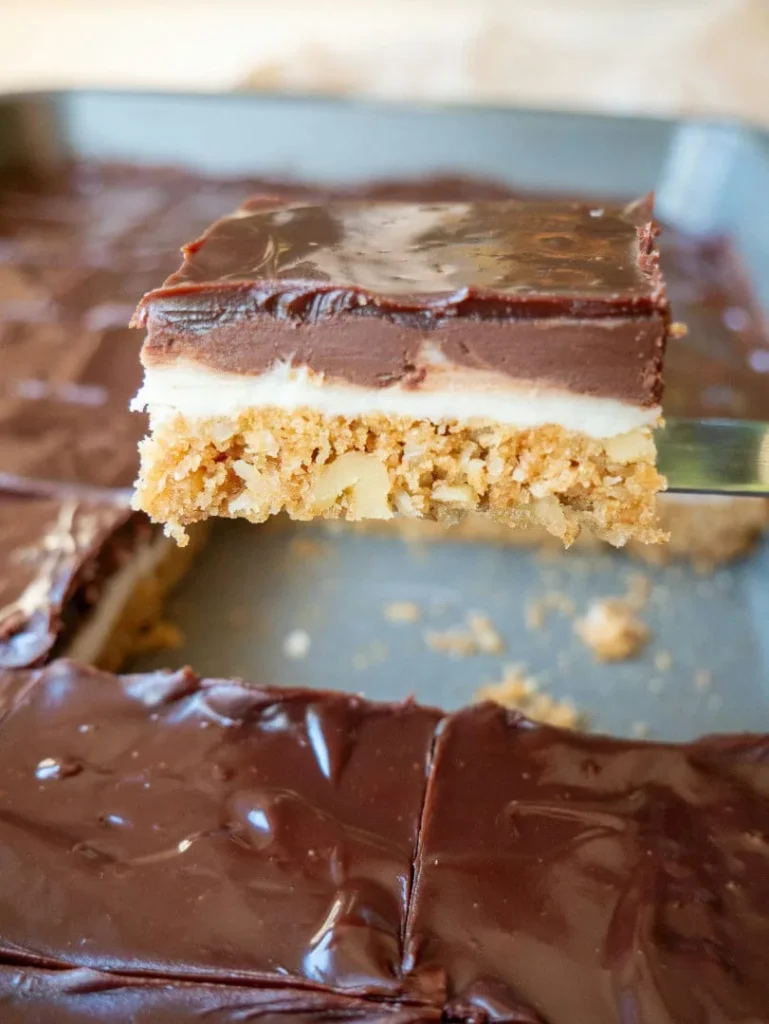 Heavenly Squares dessert bars cut into squares and served on a plate with rich chocolate and creamy layers.